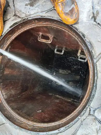 High-pressure water jet spraying inside a sewer manhole