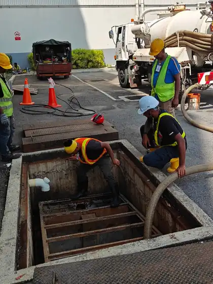Akelus crew desludging a pit with a suction hose from the vacuum tanker